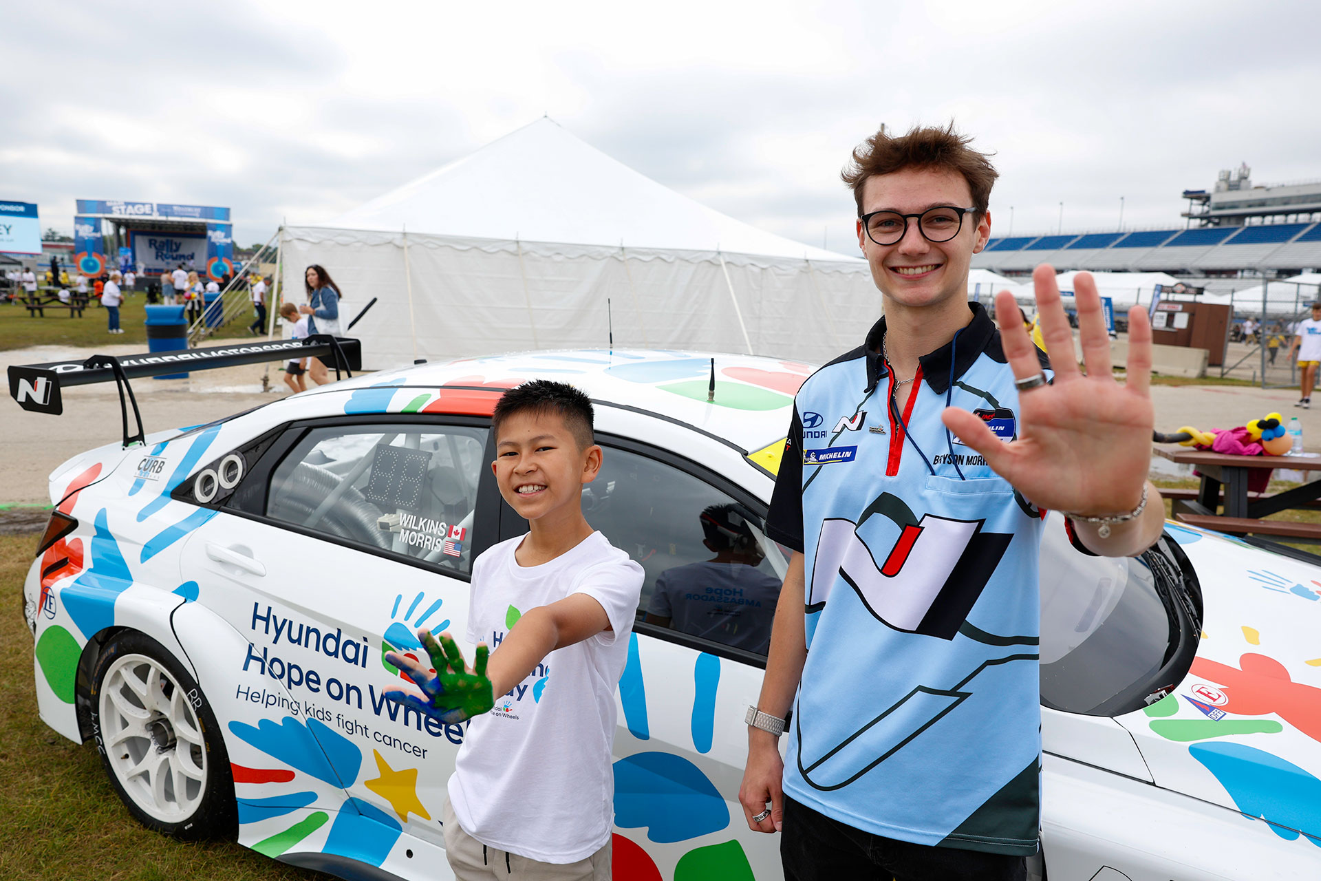 Bryson Morris, driver of the No. 33 Hyundai Elantra N TCR, stands with Hyundai Hope on Wheels National Youth Ambassador Jackson Trinh celebrating the Hyundai Hope on Wheels livery in Milwaukee, Wisc. on Sept. 13, 2025. (Photo/Ryan Miller Photography)